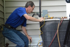 HVAC technician performing maintenance on an air conditioning unit, demonstrating essential AC upkeep for optimal home cooling.
