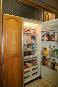 Refrigerator with open door showing various food items and condiments, emphasizing proper storage and maintenance tips for unused appliances.