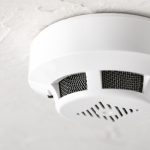 Smoke detector mounted on ceiling, emphasizing safety and importance of timely replacement for fire safety in homes.